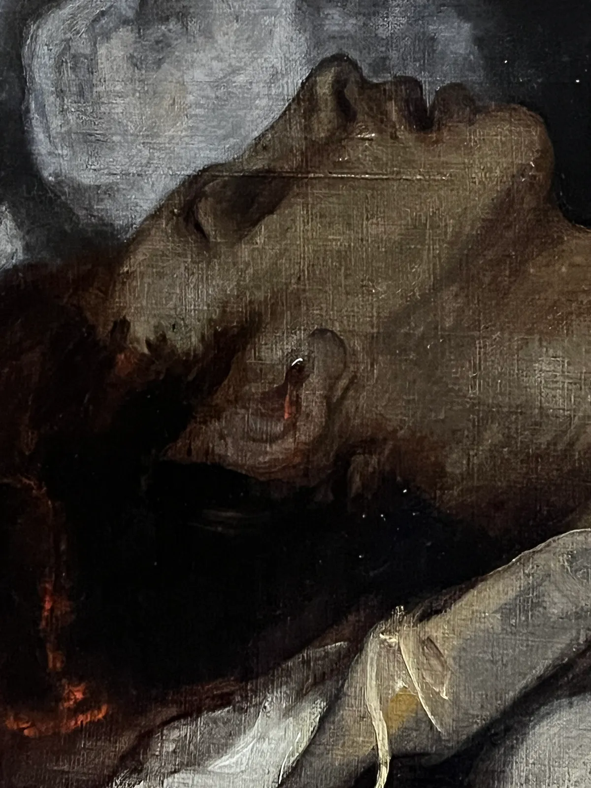 Detail of a fallen man, with blood now visible in his ear